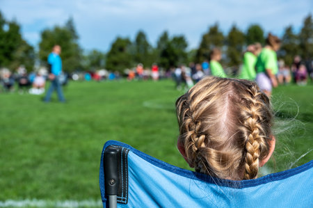 Younger sister watching a soccer game to support her sibling.の写真素材