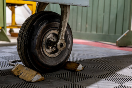 Wheel chock on the front of a parked aircraft to immobilize the tire.