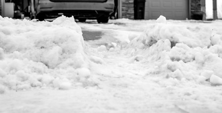 Snowbank at the end of a driveway left after city snowplows cleared a street.