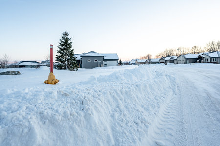 Fire hydrant with a locator protruding from a snow back along a residential street.の写真素材
