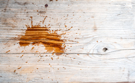 Spilled drink on a wooden picnic bench.の写真素材