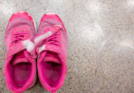 pair of worn out childrens sneakers with scuffs damaged straps.の写真素材