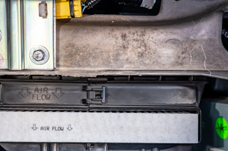 Automotive cabin air filter direction of flow arrow marked on casing.