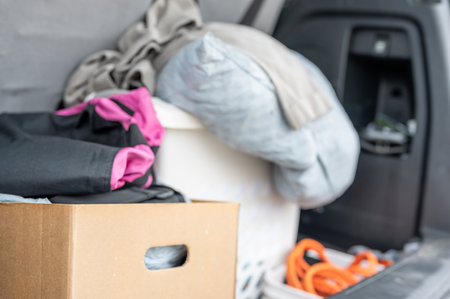 Cloths and material bagged and boxed for donation in the back of a vehicle.の写真素材