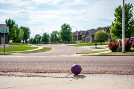 Chasing a ball that has crossed the street by rolling into a road.の写真素材