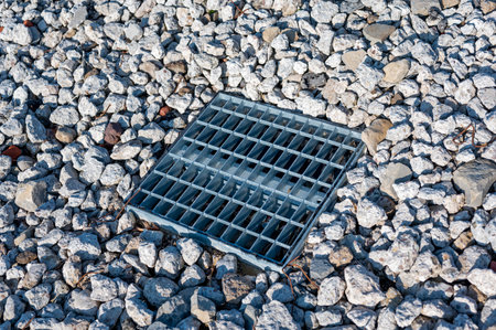 Grated storm drain inlet surrounded by rock for soil erosion controlの写真素材