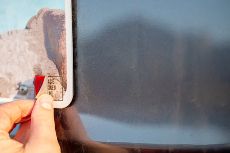 Affixing a new license registration sticker on a vehicle plate.
