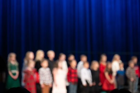 defocused elementary musical concert with children lined up on stage to sing.の写真素材