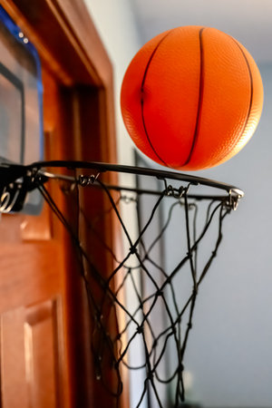 Selective focus on the netting of a miniature toy basketball hoop on the door of a bedroom.の写真素材