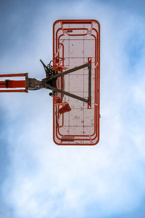 directly underneath a caged aerial work platform lift.