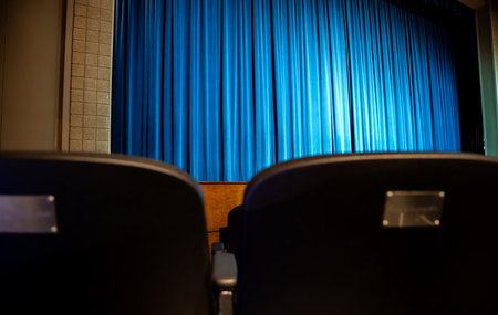 selective focus on the back of a audience chair at a community theater stage.