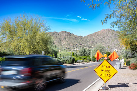 Motion blurred vehicle traveling past a road work sign for construction.の写真素材
