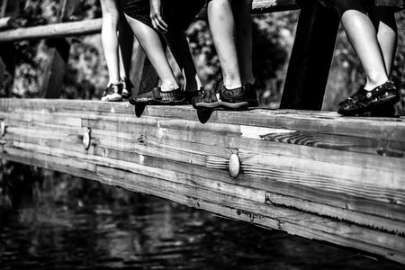 Selective focus on children crossing a wooden plank bridge over Spring Creek crossing on the...