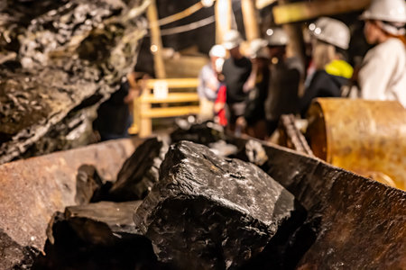 Selective focus on anthracite coal on a conveyer belt with defocused group in the Lackawanna Coal...