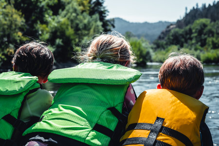 Selective focus on three children peering over a raft going down the wild and scenic Rogue Riverの写真素材