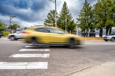 Motion blurred vehicle passing over a intersection crosswalk markings