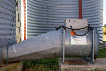 Forced air drier fan attached to a flat bottomed metal grain bins on a family farm.の写真素材