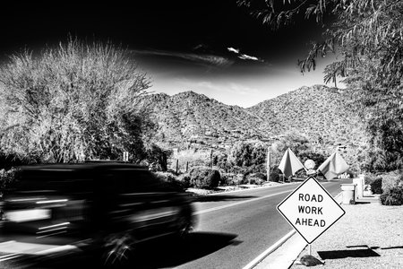Motion blurred vehicle traveling past a road work sign for construction.の写真素材