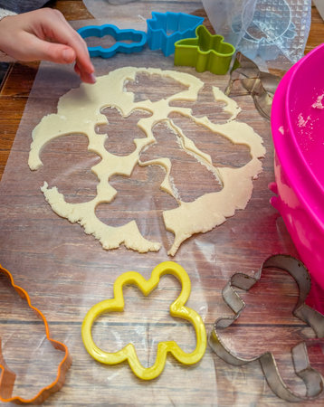 View from above making cookies with dough rolled flat and cutoutsの写真素材