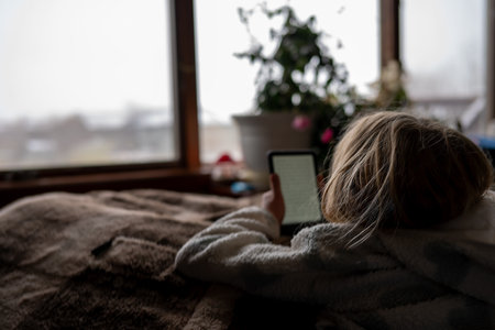Young girl using an e-reader tablet to enjoy a book.の写真素材