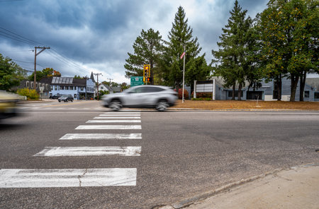 Motion blurred vehicle passing over a intersection crosswalk markingsの写真素材