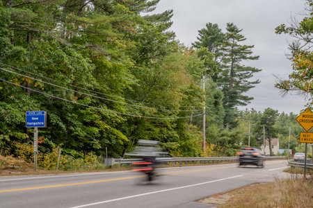Blurred vehicles speeding across the New Hampshire state line from Maine.の写真素材