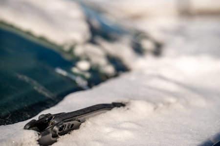 ice and snow covered front windshield wiper blades on a vehicle.の写真素材