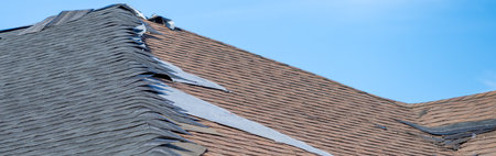 ground level view re-roofing overlay project at a residential house where new shingles are placed on top of existing tiles.の写真素材