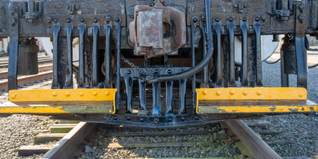 Track level view of the front grill and blade of a locomotive train.