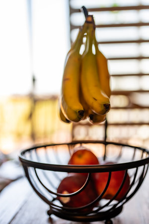 Fresh bunch of Bananas on a stand with several applesの写真素材