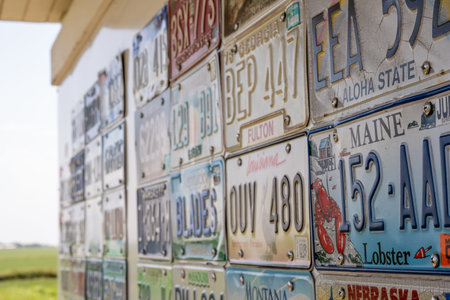 Hawkeye Point, Iowa - 6.21.2025: Collection of colorful vintage license plates displayed at a roadside attraction in Nebraska during a sunny day