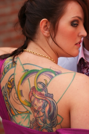 Lady looking over shoulder with fairy tattoo on backの写真素材