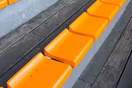 orange plastic seats on wooden stepの写真素材
