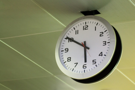 white clock hang on ceiling in public place, show time 06:50 AM or PMの写真素材