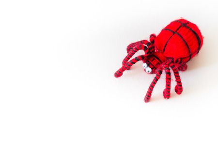 red and black spider doll, spider toy on white background free copyspace for textの写真素材