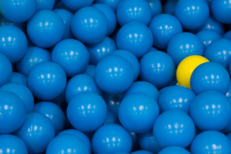 plastic balls, yellow plastic ball among blue plastic ball, concept : different, hiding power, fear, beware, spyの写真素材