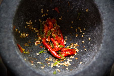 Red chili pepper in mortar, asian food equipmentの写真素材