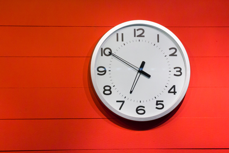 white clock wall on red wooden panel with copy space for text, concept : hurry in early morningの写真素材