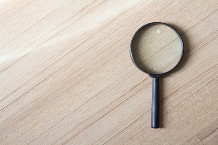 black magnifier on wooden backgroundの写真素材