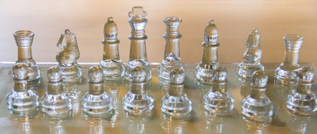 transparent chess set on wooden tableの写真素材