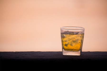 a glass of beer on concrete wall near sea background in eveningの写真素材