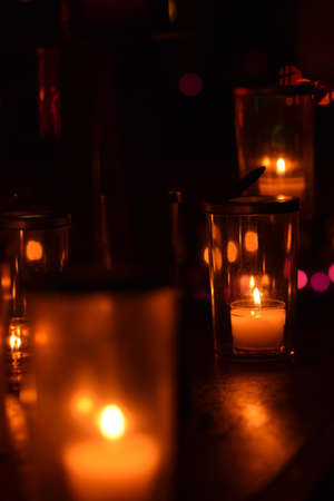 Candles in a glass vase on a dark background. Selective focus.の写真素材