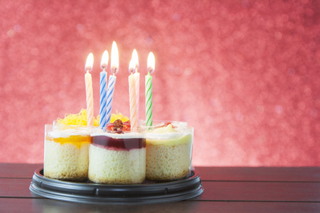Birthday cake with candles on color backgroundの写真素材