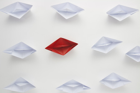  New thinking concept or individuality leadership symbol as a group of paper boat  with one...