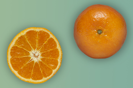 Orange fruit with half isolated on a green background pastel.の写真素材