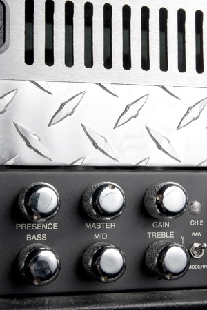 black and metallic guitar apmlifier panel with metallic shiny knobs for bass treble and middle...