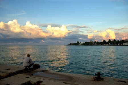 Ukraine, Black Sea, September 10, 2007 fishermen on the pier fish at dawn.のeditorial素材