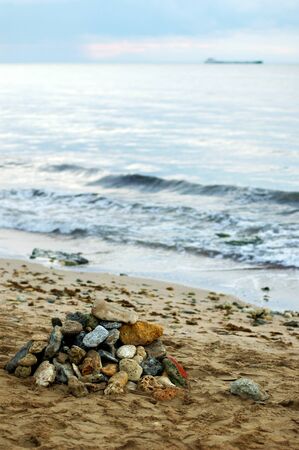 Photo of a deserted sandy beach on the Black Sea. The beach is littered with stones.の写真素材