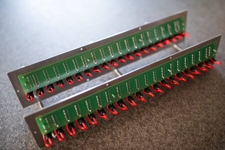 Close-up of a metal panel with microchips connected to each other with red wires in the manufacture of electronic equipment. The concept of complex technical equipment at the factoryの写真素材