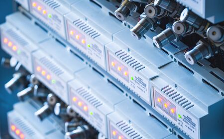Close-up numerous metal plugs hang next to instrument panels at a factory for the production of...